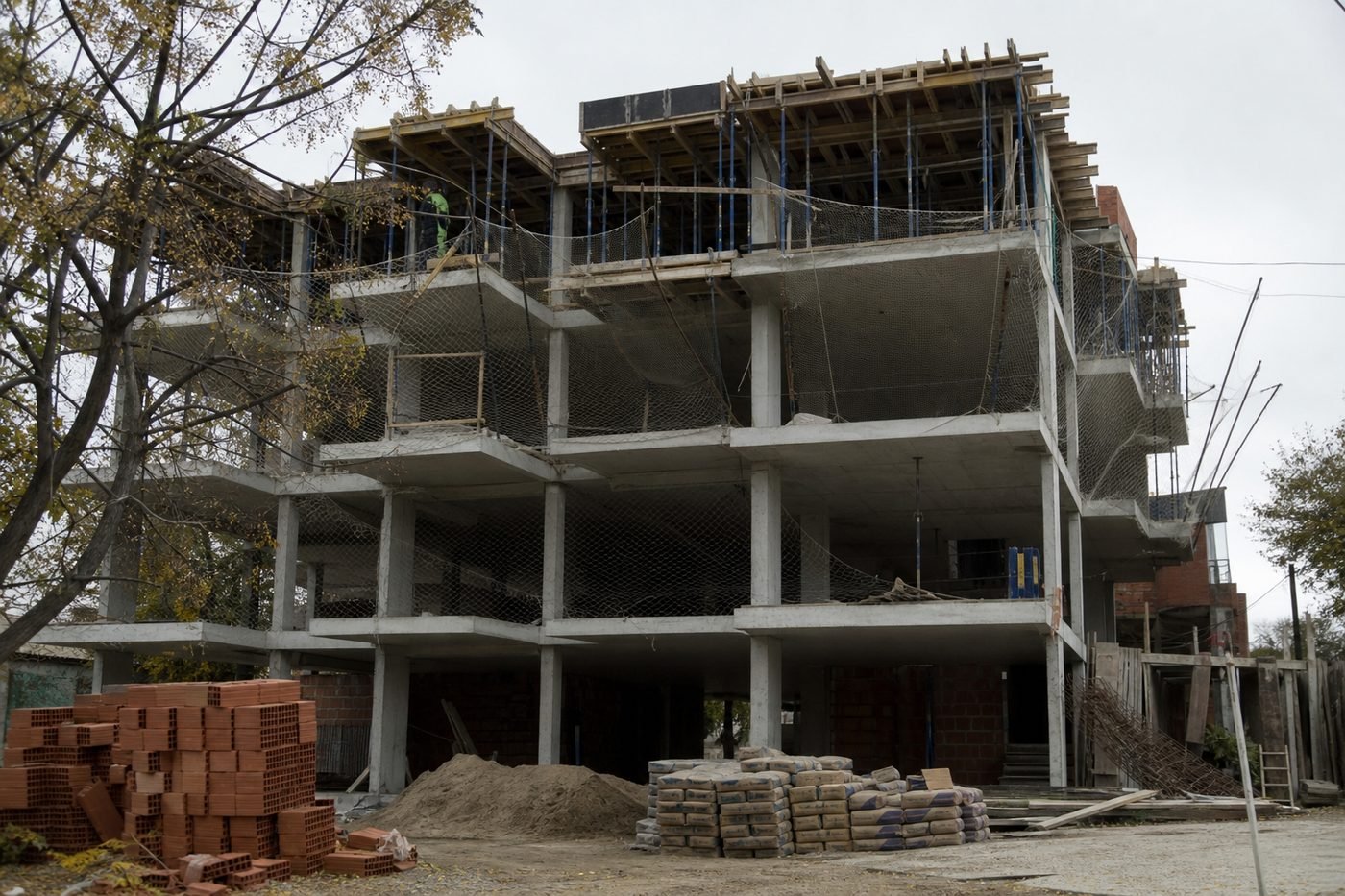 Edificio de hormigón en construcción con andamios, ilustrando la decisión de terminar obra o no empezar una nueva